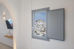a window with a view of a city at Oneiro Luxury Suites-Adults Only in Astypalaia