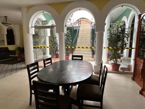uma sala de jantar com uma mesa de madeira e cadeiras em Habitaciones La Casona em Huaraz