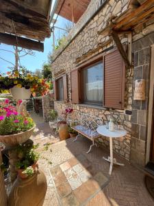 a patio with a table and a stone building at Hill Valley View in Vico Equense