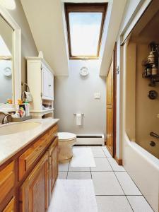La salle de bains est pourvue de toilettes, d'un lavabo et d'une fenêtre. dans l'établissement Sunny Peace, à Harwinton