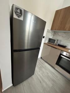 スキロスにあるFilia Skyros Suitesの- ステンレス製の冷蔵庫(電子レンジの隣のキッチン)