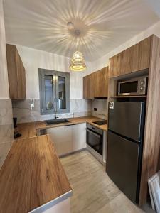 cocina con nevera negra y armarios de madera en Filia Skyros Suites, en Skiros