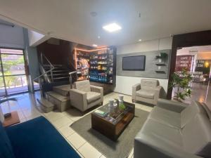 uma sala de estar com mobiliário branco e uma televisão em Hosts BR - Flat Vista Mar no Meireles em Fortaleza