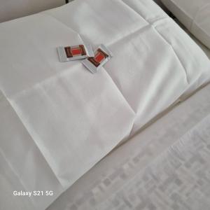 un primer plano de una cama blanca con un redinilinilinilinilonilo en B&b da Tommy Casa Vacanze, en Alseno