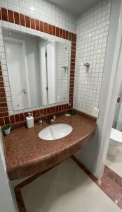 a bathroom with a sink and a mirror at Flat confortável com recepção 24h e vaga de garagem in São Paulo +9 photos
