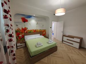 a bedroom with a bed with a flower painting on the wall at Camelia Vico Equense in Vico Equense