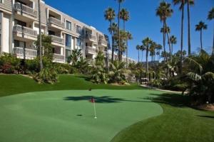 a golf course in front of a building with palm trees at Oceanview Retreat - Steps to the Beach and 2 Pools in Oceanside