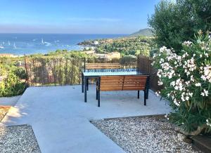 a bench sitting on a patio with a view of the ocean at Villa Grand Baie in Agay - Saint Raphael