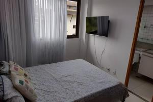 a bedroom with a bed and a tv on the wall at Malawi Beach Resort - Flat SKY in Porto De Galinhas