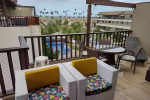a balcony with a table and chairs and a pool at Malawi Beach Resort - Flat SKY in Porto De Galinhas