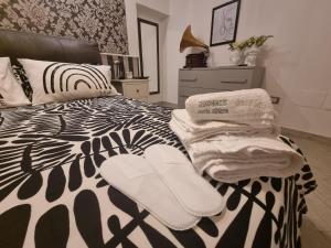 a bedroom with a black and white bed with towels on it at Home Santa Chiara Marigliano in Marigliano