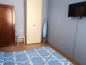 - une chambre avec un tapis bleu et blanc et une télévision dans l'établissement Bilocale in Centro a Pescara, à Pescara