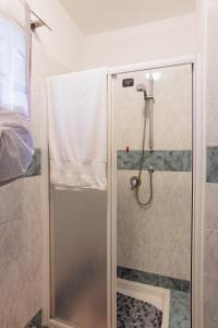 een douche met een glazen deur in de badkamer bij Casa Mati 2 in Verbania