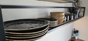 uma pilha de pratos numa prateleira numa cozinha em Kviholmi Premium Apartments em Hvolsvöllur