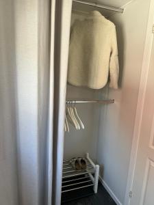 a closet with a sweater and shoes in it at Holiday house in nature-filled Vidja, near Stockholm City in Farsta
