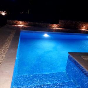 a swimming pool at night with lights in it at Holliday House Marko in Hrvace