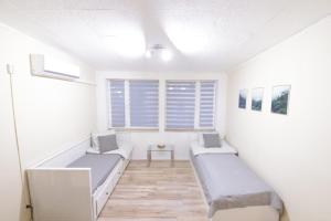 OrlinkiにあるSobieszewska Ostojaのベッド2台と窓が備わる客室です。