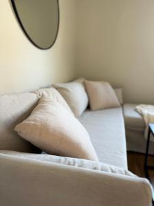 un sofá con almohadas en la sala de estar con espejo en Holiday house in nature-filled Vidja, near Stockholm City, en Farsta