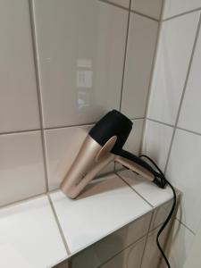 um secador de cabelo sentado numa prateleira na casa de banho em Have a nice home em Leipzig