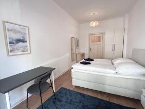 biała sypialnia z łóżkiem i biurkiem w obiekcie Be in Berlin Apartments at Charlottenburg Castle w Berlinie