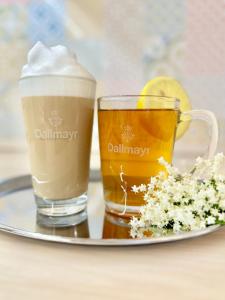 two glasses of beer and a plate of flowers at Éllő Residence in Veszprém