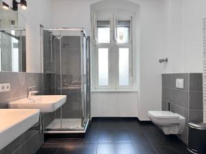 łazienka z 2 umywalkami, prysznicem i toaletą w obiekcie Be in Berlin Apartments at Charlottenburg Castle w Berlinie