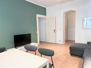 a living room with a couch and a table and chairs at Be in Berlin Apartments at Charlottenburg Castle in Berlin