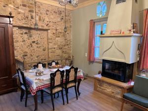 ein Esszimmer mit einem Tisch und einem Kamin in der Unterkunft Irene's Mansion in Vrontádos