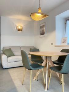 een woonkamer met een tafel en stoelen en een bank bij Casa di Maggie 1 in Carisolo