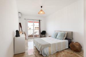 una camera bianca con un letto e una finestra di Spacieux appartement de 114 m2 à 5 min des plages - proximité tous commerces et transports a Antibes