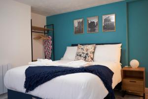 una camera da letto con una parete blu e un letto di Garden Apartment by Kahuna Stays 