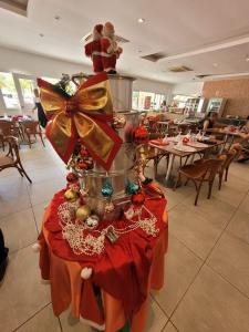 a christmas tree on a table in a restaurant at Apartamento com varanda Reserva do Sahy in Mangaratiba +16 photos