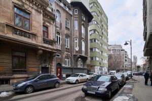 um grupo de carros estacionados numa rua da cidade em Attic Downtown-terrace by CityLife Suites em Bucareste