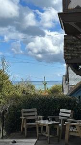 - deux tables de pique-nique et des bancs installés à côté de l'océan dans l'établissement The Coldstreamer, à Gulval
