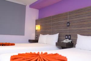 カンクンにあるホテル カビアのベッド2台、電話が備わるホテルルームです。
