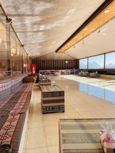 una piscina con varias mesas y una habitación grande en Siwar Luxury Camp en Wadi Rum