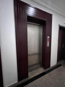 een bruine liftdeur in een gebouw bij Blue Umbrella in Muscat