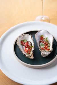two oysters on a plate with a glass of wine at Watersmeet Hotel in Woolacombe