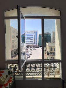 een raam met uitzicht op de stad bij Blue Umbrella in Muscat