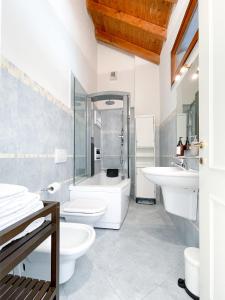 uma casa de banho com 2 WC, uma banheira e um lavatório. em Villa Luminosa Laglio - Private Parking, Garden em Laglio