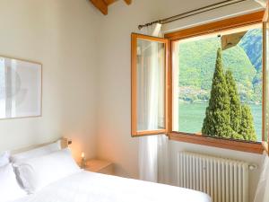 um quarto com uma cama branca e uma janela em Villa Luminosa Laglio - Private Parking, Garden em Laglio
