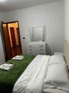 sypialnia z łóżkiem i komodą z lustrem w obiekcie Iri Apartment w Durrës