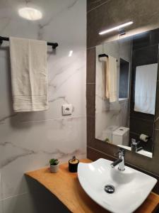 a bathroom with a white sink and a mirror at Casa do Canastro in Mondim de Basto