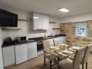 a kitchen and dining room with a table and chairs at Casa do Canastro in Mondim de Basto