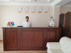 a man standing behind a counter in a room at Al-Khabib in Bukhara
