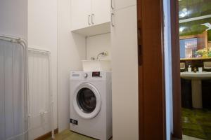 uma máquina de lavar roupa na casa de banho com um lavatório em La Casa di Carmen em Tarvisio