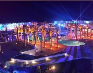 a resort with palm trees and a pool at night at Mountain view North Coast Ras elhekma, Tart's Home, Families only in Ras Elhekma +56 photos