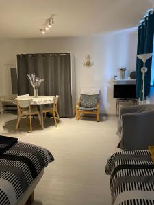 a living room with a table and chairs and a piano at Studio La source in Rochefort