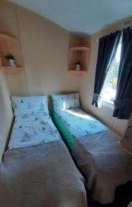 2 camas en una habitación pequeña con ventana en 7 Lakes Country Park, 38 Sunset View, en Crowle
