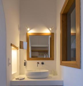 a bathroom with a sink and a mirror at Oneiro Luxury Suites-Adults Only in Astypalaia Town